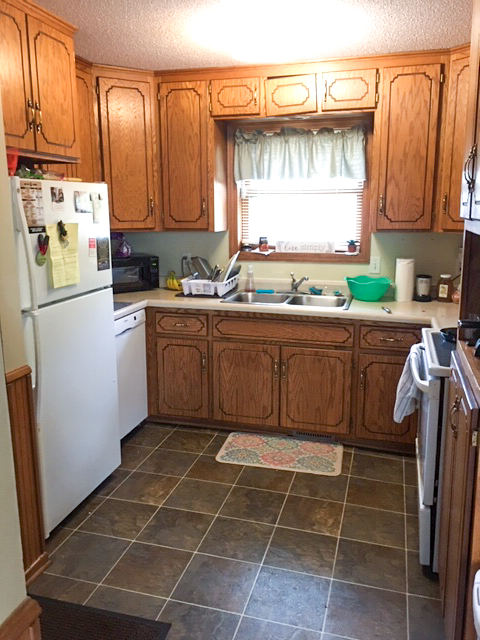 clean rental kitchen with wood cabinets