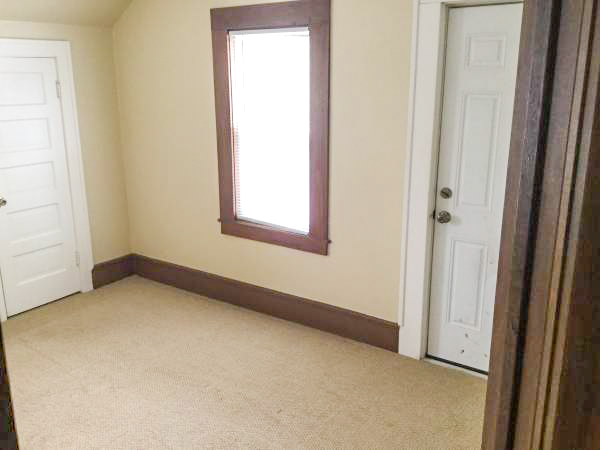 move-in ready bedroom with carpet and dark wood trim