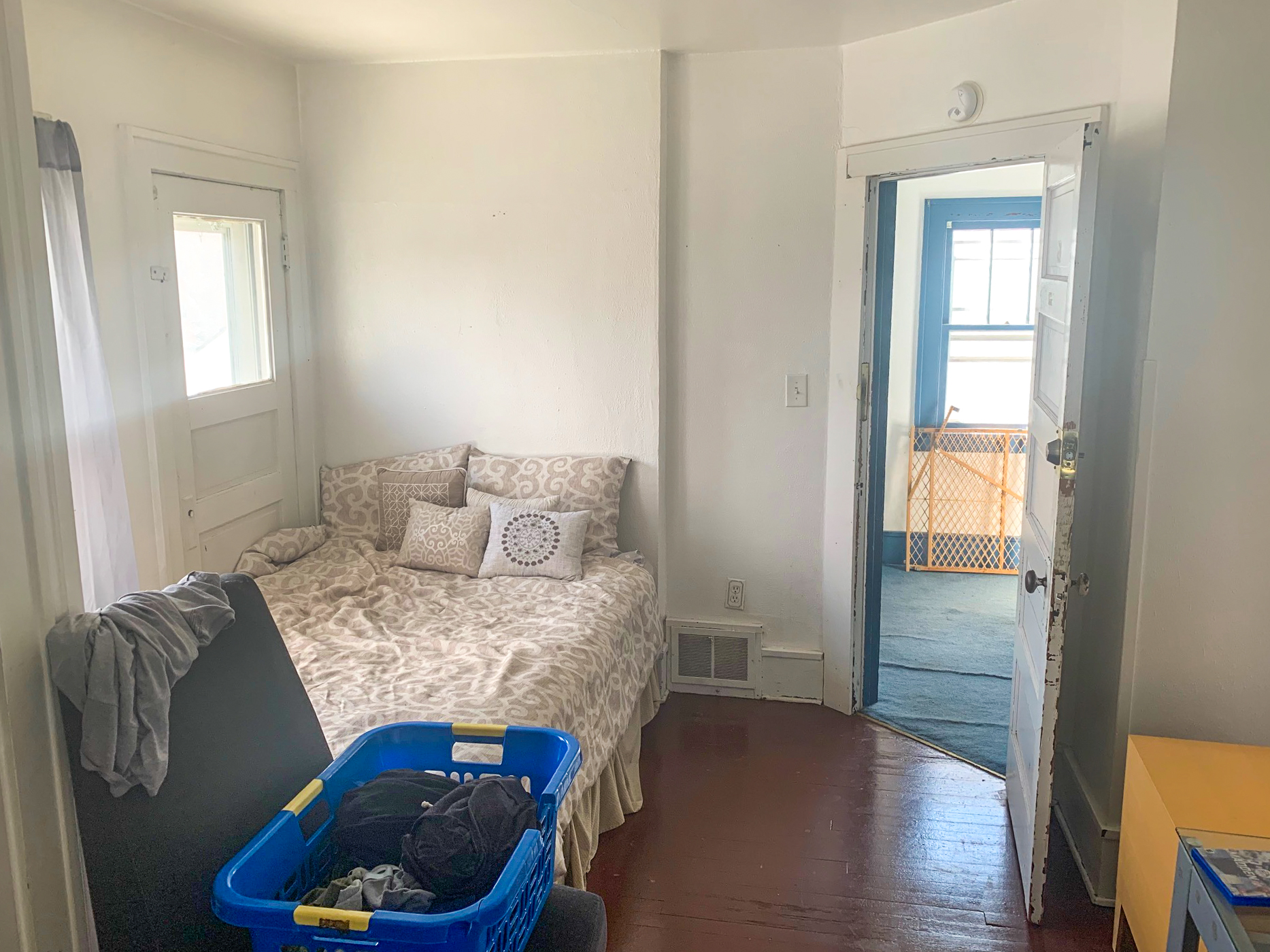 white corner bedroom with dark wood floor